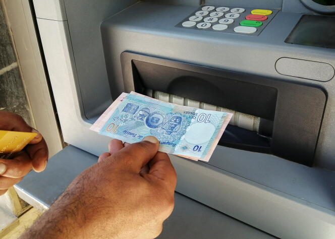 Un homme retire de l’argent à un distributeur automatique, à Tunis, en mai 2021.
