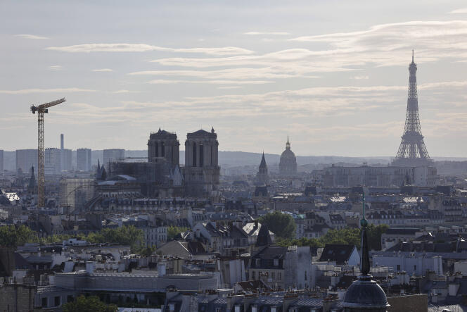 A picture taken in Paris, on July 9, 2020, shows Notre Dame cathedral, the Eiffel Tower and roofs of Paris. 