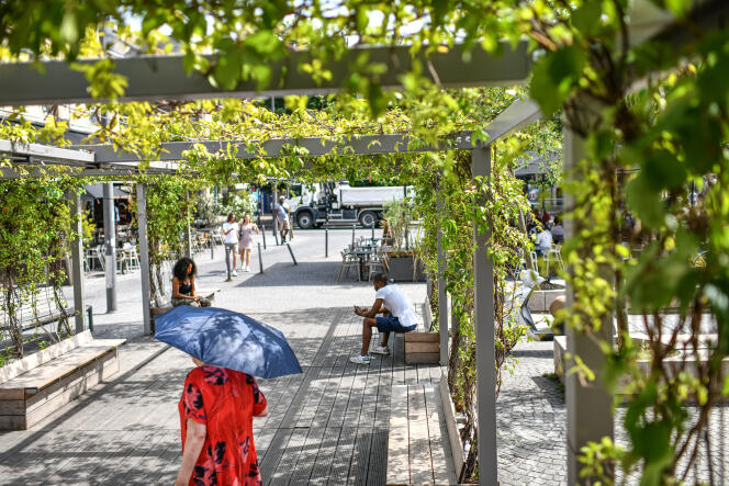 Lors de la canicule, des personnes se protègent du soleil sous la pergola installée par la municipalité place de la Victoire, à Bordeaux, le 16 juin 2022.