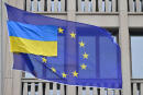 A smaller Ukrainian flag flies next to a flag of the European Union in front of the EU-representation office in Berlin on April 5, 2022. (Photo by John MACDOUGALL / AFP)