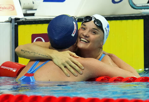 Sarah Sjostrom, left, of Sweden celebrates with Melanie Henique of France after winning the women's 50m butterfly final at the 19th FINA World Championships in Budapest, Hungary, Friday, June 24, 2022. (AP Photo/Petr David Josek)