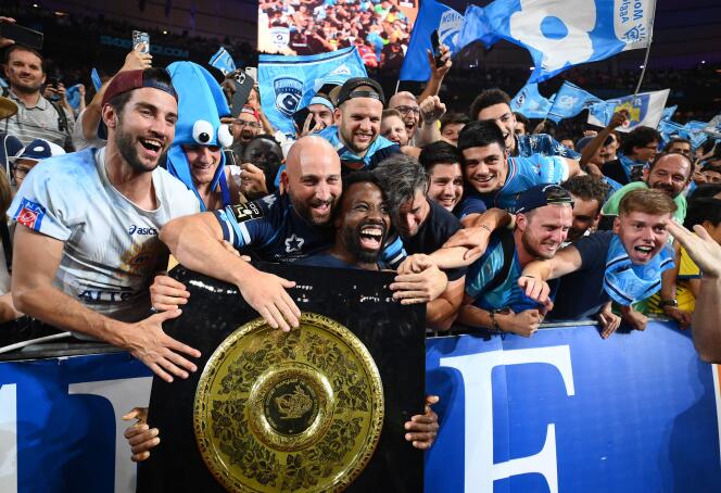 Montpellier Herault Club's French flanker Fulgence Ouedraogo (C) and supporters celebrate with the Bouclier de Brennus trophy after winning the French Top 14 final rugby union final against Castres Olympique at Stade de France stadium in Saint-Denis, on June 24, 2022.