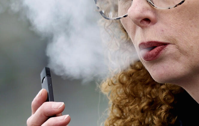 Une femme expire en vapotant une cigarette électronique à Vancouver, au Canada, en avril 2019. 