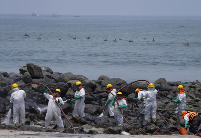 Des équipes de nettoyage sur la plage de Pocitos contaminée par une marée noire, à Ancon, au Pérou, le 15 février 2022.
