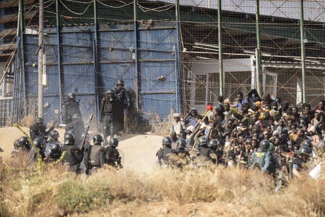 Des policiers antiémeute tentent d’empêcher les migrants, sur le territoire marocain, de forcer le passage vers l’enclave espagnole de Melilla, vendredi 24 juin 2022. 