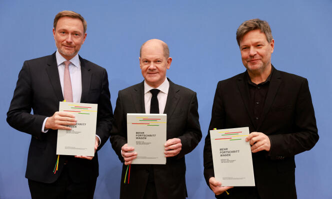 Le chancelier allemand Olaf Scholz (au centre), le co-leader des Verts et ministre allemand de l’économie et du climat, Robert Habeck (à droite), et le chef du parti libéral-démocrate FDP et ministre allemand des finances Christian Lindner posent avec des copies de l’accord de coalition à l’issue d’une cérémonie de signature à Berlin, le 7 décembre 2021.