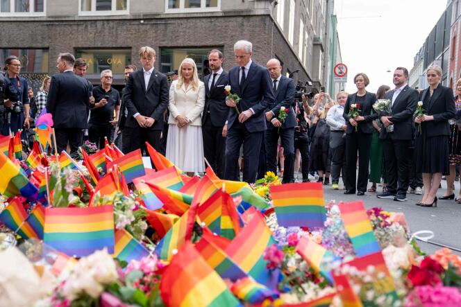 La princesa heredera Mette-Marit de Noruega (de blanco), el príncipe heredero Haakon de Noruega (a su izquierda) y el primer ministro noruego Jonas Gahr Store (con una flor) rinden homenaje a las víctimas de un tiroteo en Oslo, el 25 de junio. , 2022.