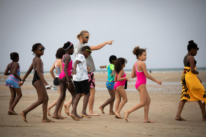 Des enfants et un bénévole des « Oubliés des vacances », une campagne organisée par le Secours Populaire, sur la plage de Cabourg (Calvados), en août 2020.