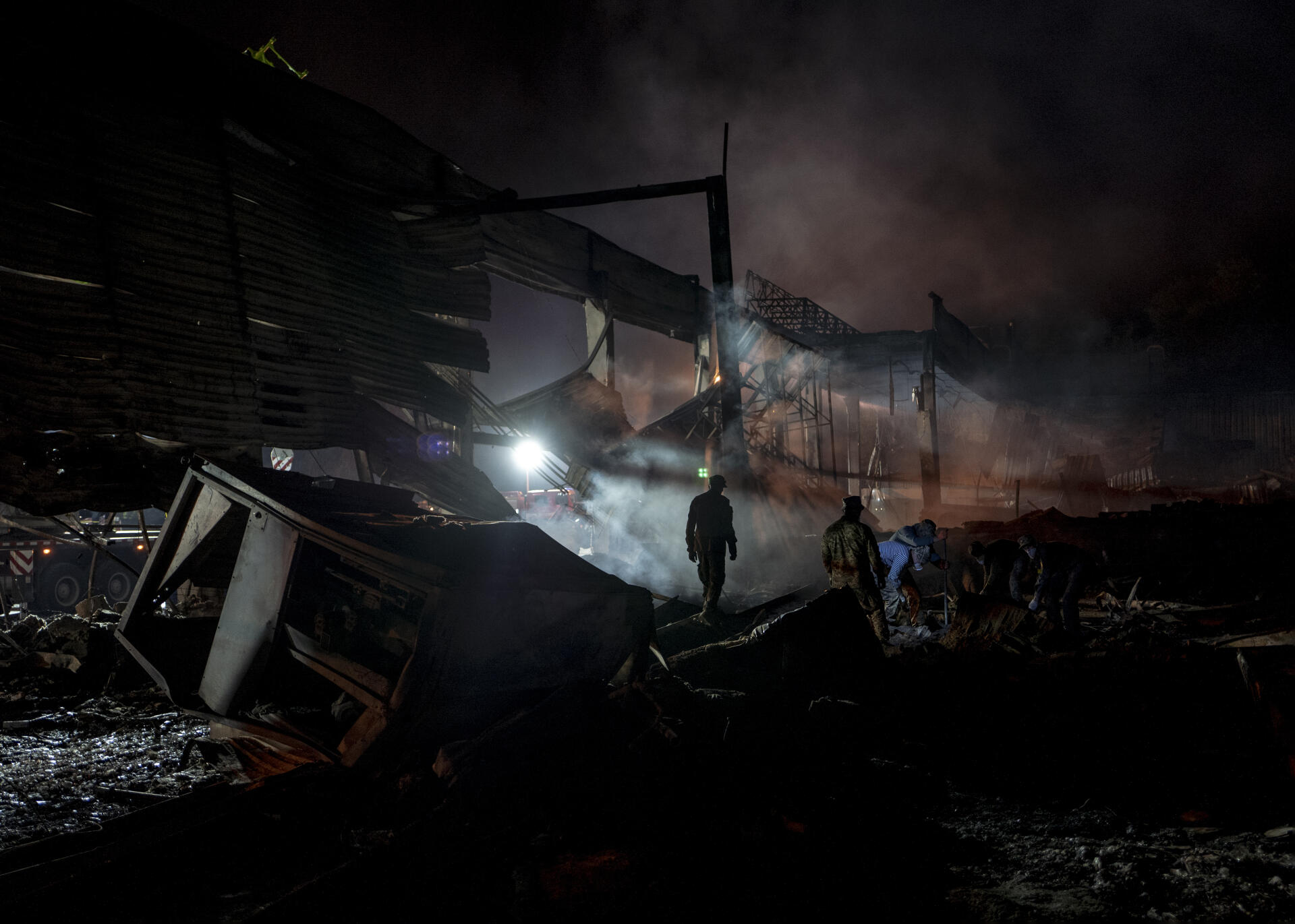 Des centaines de secouristes et de militaires déblayent les décombres suite aux frappes qui ont touché un centre commercial à Krementchouk, en Ukraine, le 27 juin 2022.