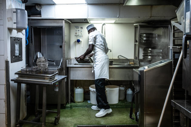 Dieuvenor, a dishwasher, arrived from Haiti in 2017. His regularization procedure is currently being examined. Pictured here in the Café du Commerce kitchen in Paris, June 2022.