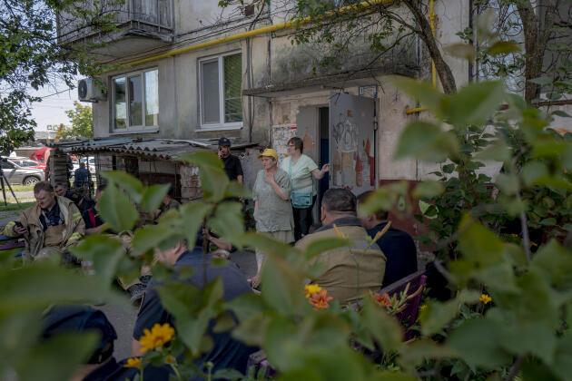 Residents emerge from their homes in the aftermath of Russian strikes that hit a shopping mall in Kremenchuk, Ukraine, June 28, 2022.
