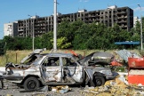Une voiture détruite au pied d’un immeuble brûlé, à Marioupol, le 1er juillet 2022.