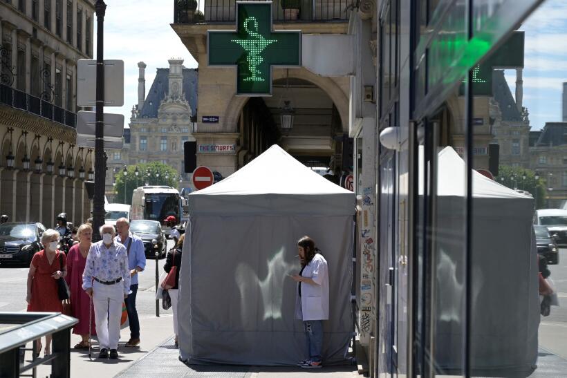 Un personnel médical fume près d’une tente de dépistage placée devant une pharmacie à Paris, le 29 juin 2022. 
