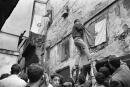 (FILES) In this file photo taken on July 6, 1962, Young Algerians hangs a national flag on a wall in the Casbah of Algiers, a dau after the proclamation of the independence of his country. Algeria marks 60 years of independence from France on July 5, but rival narratives over atrocities committed during over a century of colonial rule continue to trigger bitter diplomatic tensions. The North African country won its independence following a gruelling eight-year war which ended with the signing in March 1962 of the Evian Accords. (Photo by AFP)
