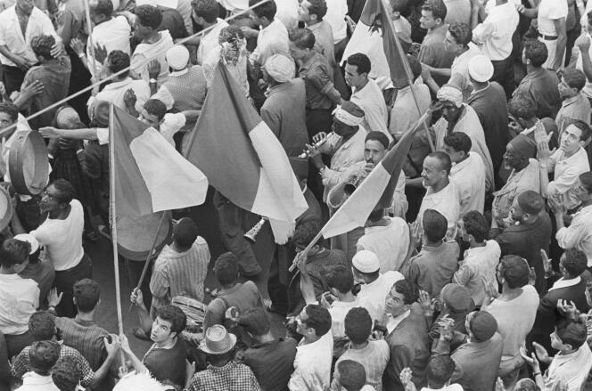 A crowd waves the Algerian national flag and plays traditional musical instruments in Algiers on July 1, 1962, the day of the referendum on self-determination.