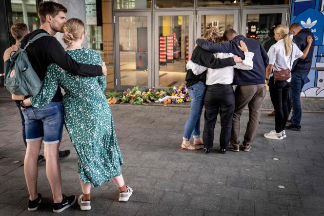 Des gens rendent hommage aux trois personnes tuées dimanche lors d’une fusillade dans un centre commercial de Copenhague (Danemark), le 4 juillet 2022.