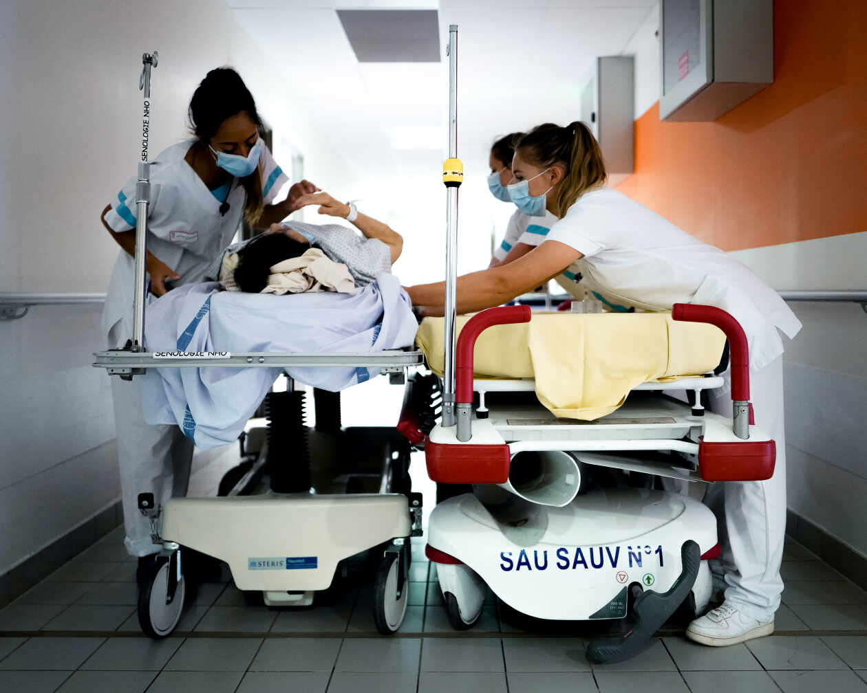 Trois infirmières installent une patiente sur un nouveau brancard aux urgences de l’hôpital de la Source, à Orléans, le 15 juin 2022.