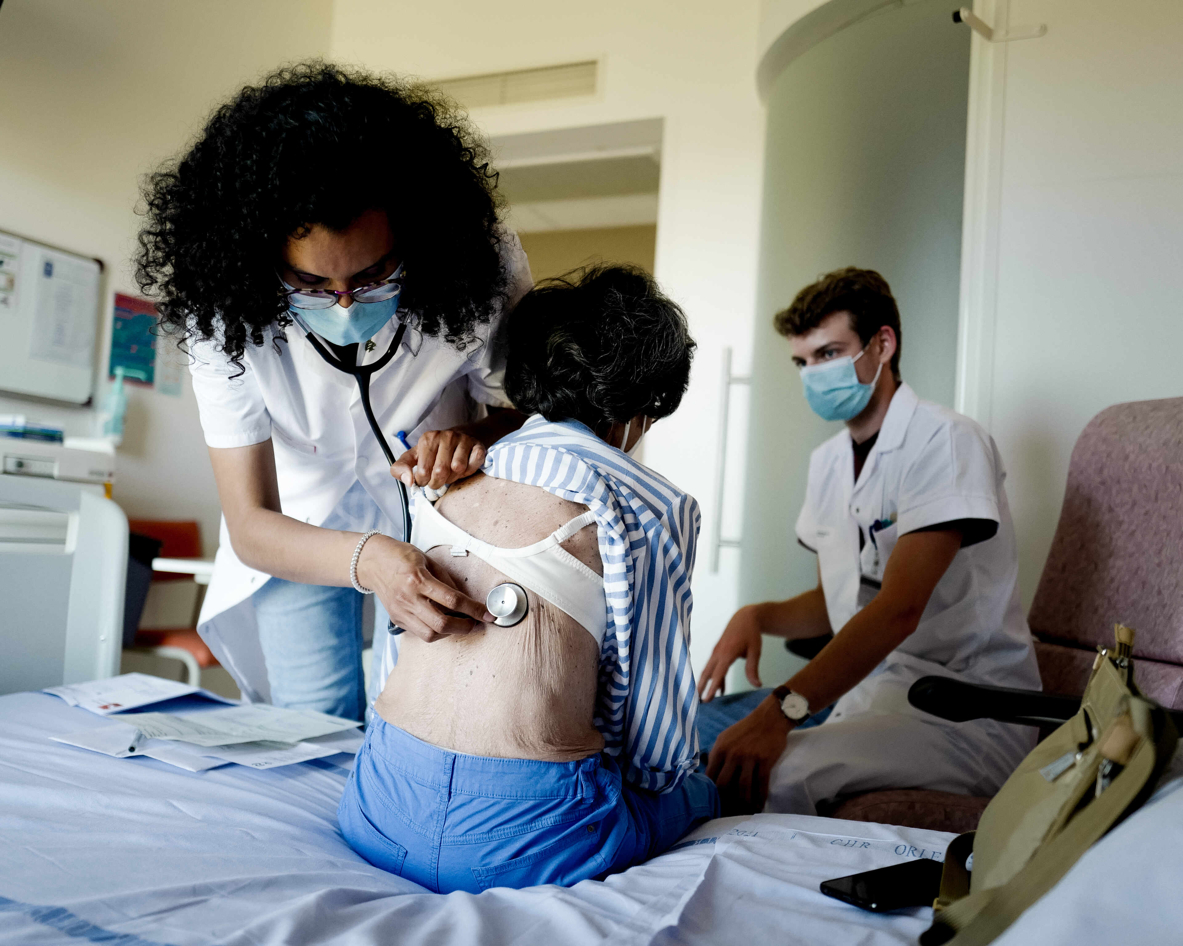 Nada Ibrahim Nasser, rhumatologue, ausculte une patiente dans sa chambre, accompagnée d’Edo, jeune interne, au service de rhumatologie de l’hôpital de la Source, à Orléans, le 15 juin 2022.