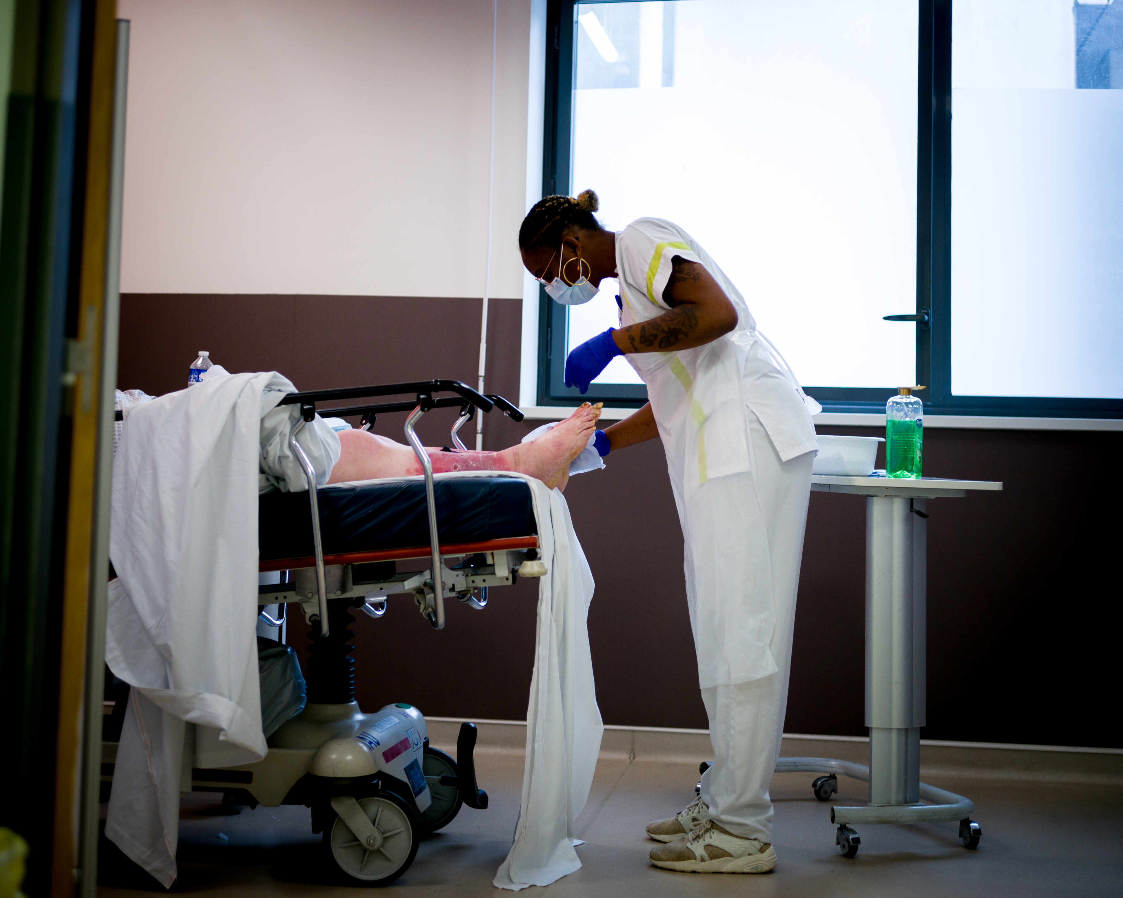 Une aide-soignante examine les pieds d’un patient, aux urgences de l’hôpital de la Source, à Orléans, le 15 juin 2022.