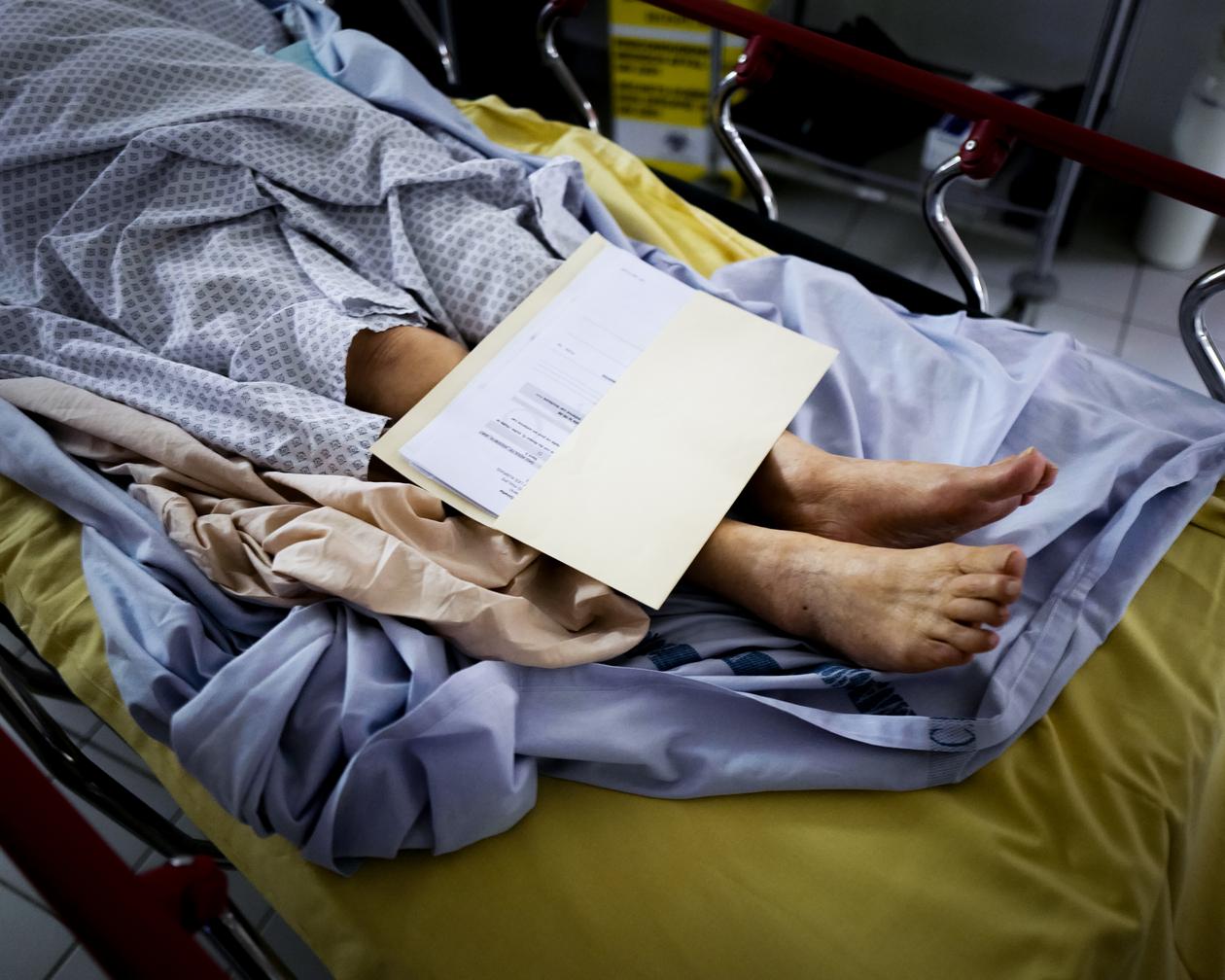 Une patiente attend d’être déplacée, son dossier médical posé sur ses pieds, aux urgences de l’hôpital de la Source, à Orléans, le 15 juin 2022.