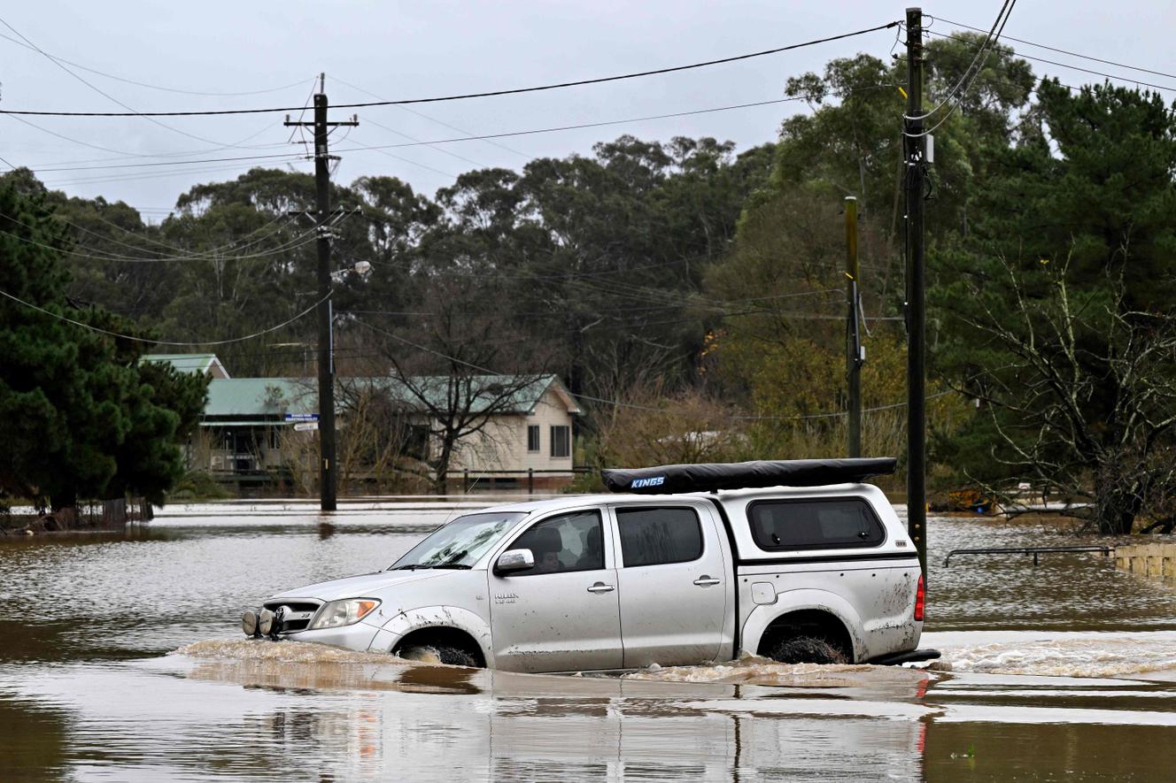 A resident tries to cross the overflowing Nepean following torrential rains that flooded western Sydney on July 5, 2022.
