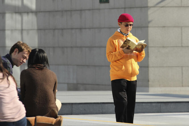 In this December 2013, photo, Xiao Jianhua, a Chinese-born Canadian billionaire, reads a book outside the International Finance Centre in Hong Kong. 