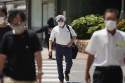 Malgré la chaleur, la plupart des Japonais continuent à porter le masque dans la rue, comme ici, le 27 juin 2022, à Tokyo.