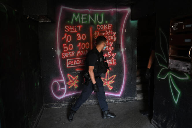 Un policier passe devant un « menu » annonçant le prix d’achat pour des différentes drogues, dans le parc Kalliste, à Marseille, le 10 mai 2022.