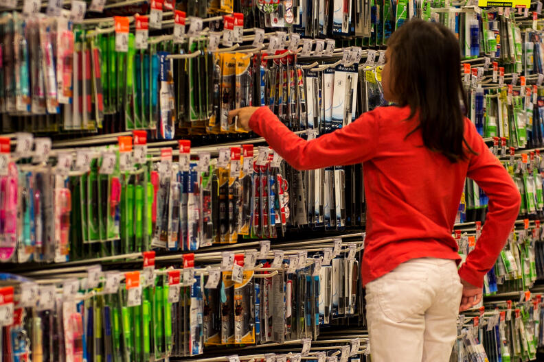 A girl looks at pens and pencils as parents and their children shop for school supplies on August 18, 2016 at a supermarket in Englos, northen France, ahead of the start of the new school year. - The average back-to-school costs will remain stable this year, at 190,24 euros for a child entering the first year of secondary school, revealed the Familles de France on August 17, 2016. (Photo by PHILIPPE HUGUEN / AFP)