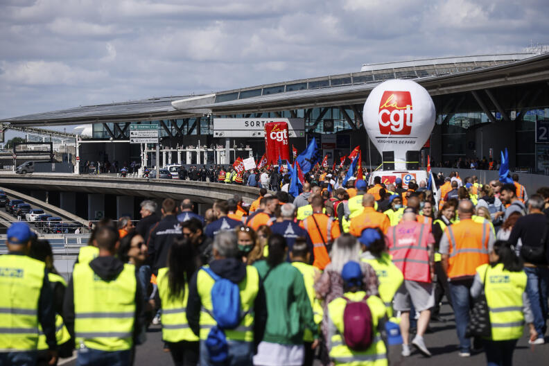 Unionists strikers demonstrate outside a terminal Friday, July 1, 2022 at Roissy airport, north of Paris. Flights from Roissy-Charles de Gaulle airport in Paris and other French airports faced disruptions Friday as airport workers held a strike and protests to demand salary hikes to keep up with inflation. It's the latest trouble to hit global airports this summer, as travel resurges after two years of virus restrictions. (AP Photo/ Thomas Padilla)