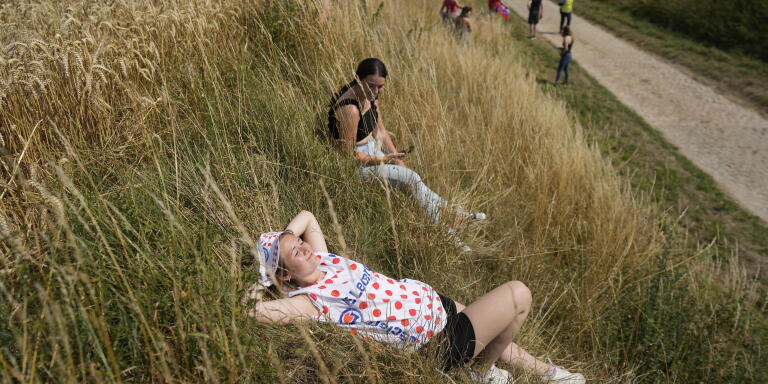 Spectators wait for the riders to pass over a stretch of cobblestone sector during the fifth stage of the Tour de France cycling race over 157 kilometers (97.6 miles) with start in Lille Metropole and finish in Arenberg Porte du Hainaut, France, Wednesday, July 6, 2022. (AP Photo/Thibault Camus)