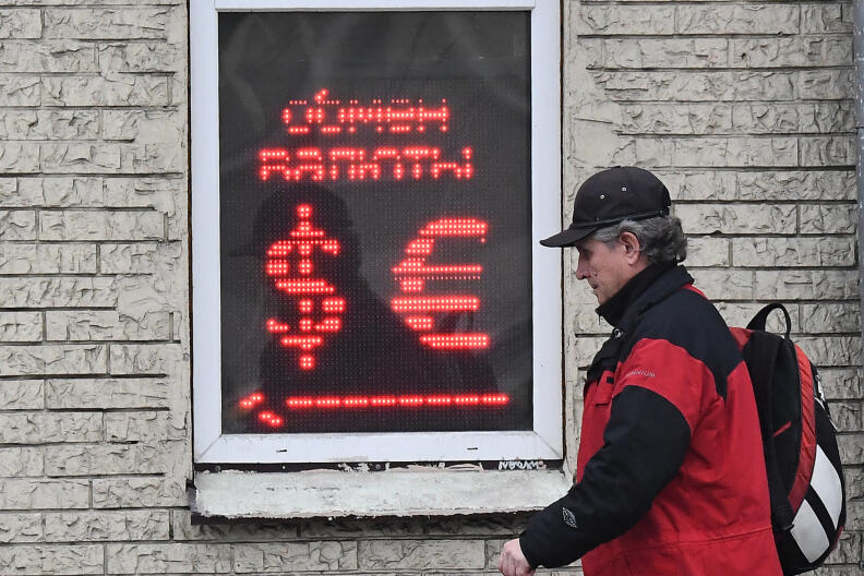 A man walks past a currency exchange office in Moscow on March 10, 2020. - Russia's RTS stock index dived more than 10 percent on opening March 10 after a public holiday, following a crash in oil prices that saw the ruble and global markets post massive losses. The Russian ruble tumbled in value March 9 to trade at 75 to the US dollar, a rate last seen in early 2016. On March 10, it rose slightly and was trading at around 72 to the dollar and 82 to the euro. (Photo by Yuri KADOBNOV / AFP)