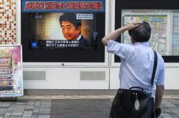 TOPSHOT - A man looks at a television broadcast showing news about the attack on former Japanese prime minister Shinzo Abe earlier in the day, along a street of Tokyo on July 8, 2022. Shinzo Abe was shot at a campaign event in the city of Nara on July 8, a government spokesman said, as local media reported the nation's longest-serving premier was showing no vital signs. (Photo by Charly TRIBALLEAU / AFP)