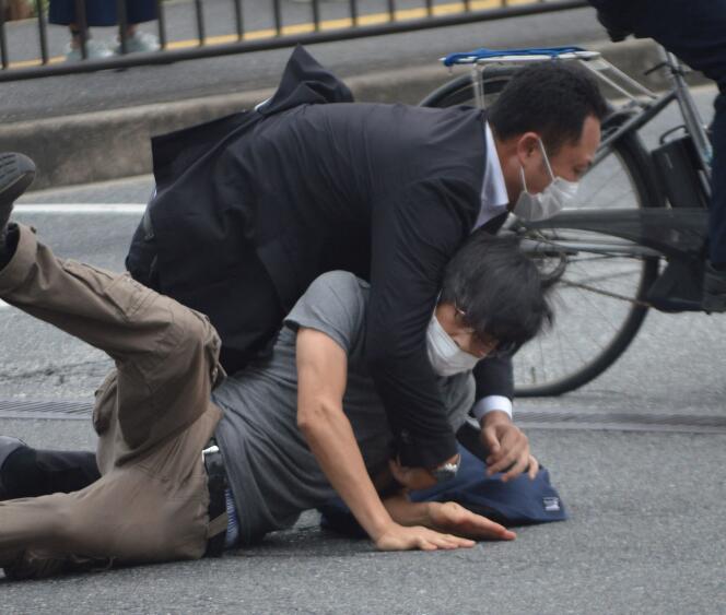 A man (bottom) suspected of shooting former Japanese prime minister Shinzo Abe is tackled to the ground by police at Yamato Saidaiji Station in the city of Nara on July 8, 2022.