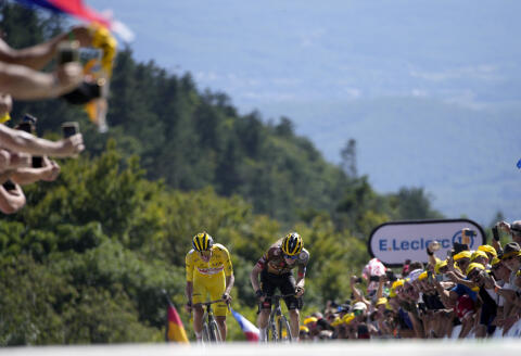 Slovenia's Tadej Pogacar, wearing the overall leader's yellow jersey, crosses the finish line ahead of Denmark's Jonas Vingegaard to win the seventh stage of the Tour de France cycling race over 176.5 kilometers (109.7 miles) with start Tomblaine and finish in La Super Planche des Belles Filles, France, Friday, July 8, 2022. (AP Photo/Daniel Cole)