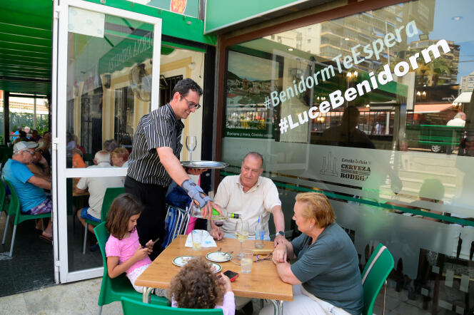 Le propriétaire du restaurant « Taberna Andaluza », Pablo Gonzalez, sert des clients, à la plage de Levante à Benidorm, le 7 juin 2022.
