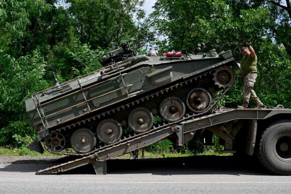 Un véhicule blindé de transport de troupes britannique FV-103 Spartan est déchargé, dans la campagne près de Bakhmout, dans l’est de l’Ukraine, le 9 juillet 2022.