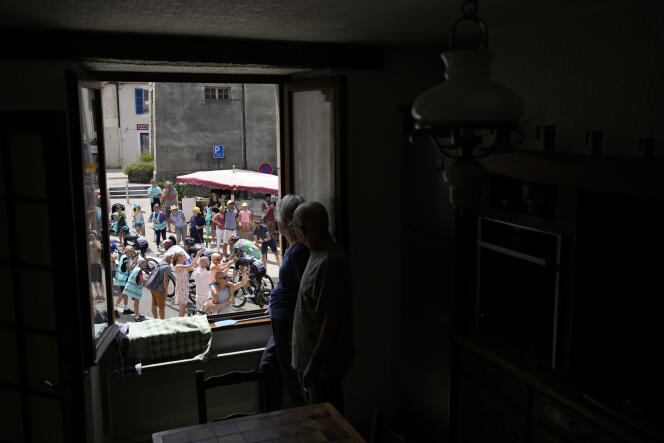 Espectadores en la ventana de su casa, durante la 8ᵉ etapa del Tour de Francia, entre Dole y Lausana, el 9 de julio de 2022. 