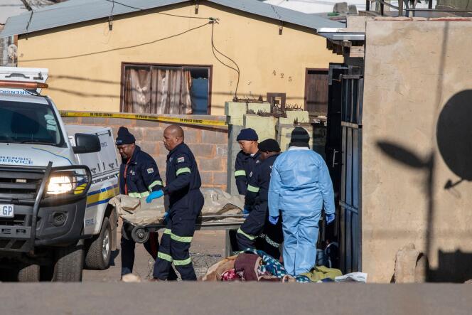 Ein forensisches Team trägt am 10. Juli 2022 in Soweto, Südafrika, die Leiche eines Opfers einer Schießerei auf einer Trage.