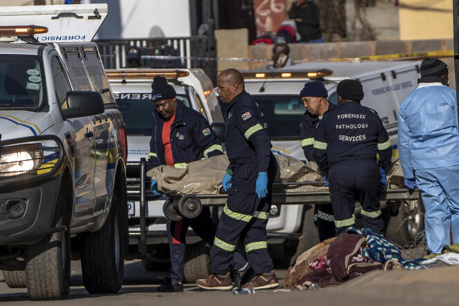 Un corps est évacué de la scène d’une fusillade dans un bar à Soweto, en Afrique du Sud, le dimanche 10 juillet 2022, qui a coûté la vie à quinze personnes. 