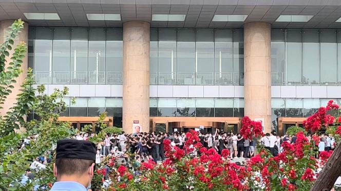 Une capture d’écran montre des manifestants se bagarrant avec le personnel de sécurité lors d’une manifestation contre le gel des dépôts par des banques rurales, devant un bâtiment de la Banque populaire de Chine à Zhengzhou, en Chine, le 10 juillet 2022.
