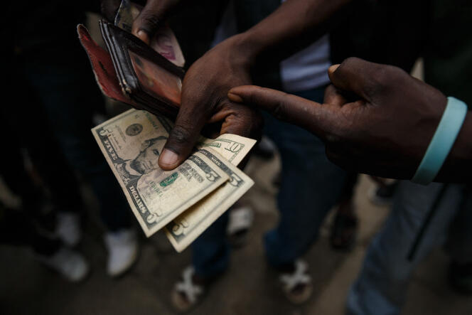 Un Zimbabwéen paye en dollars américains, à Harare, en 2019.