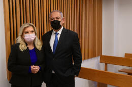 Former Israeli Prime Minister Benjamin Netanyahu (R) and his wife Sarah stand in the Tel Aviv Magistrate's Court, on 10 January 2022, ahead of a preliminary hearing in their defamation lawsuit against former Prime Minister Ehud Olmert, who called them "mentally ill" in interviews. (Photo by Avshalom SASSONI / POOL / AFP)