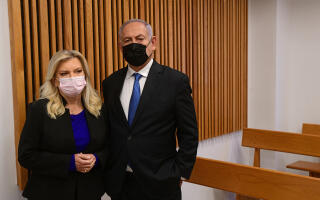 Former Israeli Prime Minister Benjamin Netanyahu (R) and his wife Sarah stand in the Tel Aviv Magistrate's Court, on 10 January 2022, ahead of a preliminary hearing in their defamation lawsuit against former Prime Minister Ehud Olmert, who called them "mentally ill" in interviews. (Photo by Avshalom SASSONI / POOL / AFP)