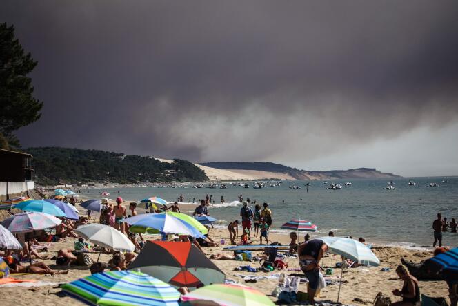 A black cloud of smoke from a fire that hit La Teste-de-Buch forest rises behind the Pyla Dune