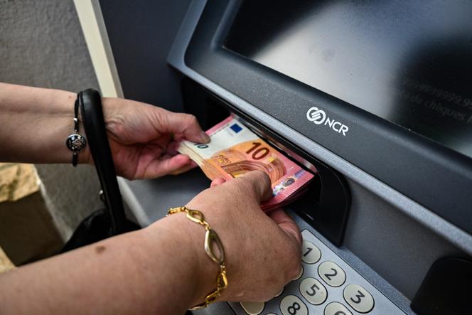 Una donna deposita denaro sul suo conto in banca. A Cours-la-Ville (Rodano), 29 aprile 2022.