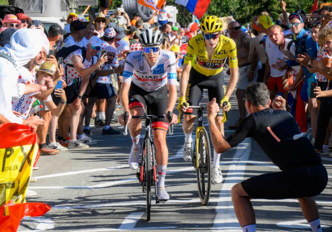 Tadej Pogacar (in white jersey) and Jonas Vingegaard (in yellow jersey) climbing Alpe d'Huez on Thursday 14 July.