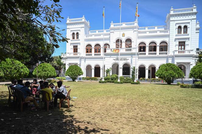 Demonstrators sit in the lawn of the office building of Sri Lanka's prime minister in Colombo on July 14, 2022, a day after thousands of anti-government protesters stormed into Sri Lanka Prime Minister Ranil Wickremesinghe's office after he was named acting president.