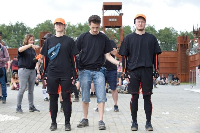 Deux des scientifiques participant à l’étude des mouvements de foule lors du festival Hellfest, sont équipés de capteurs et portent des casquettes orange pour être visibles. A Clisson, le 26 juin 2022.