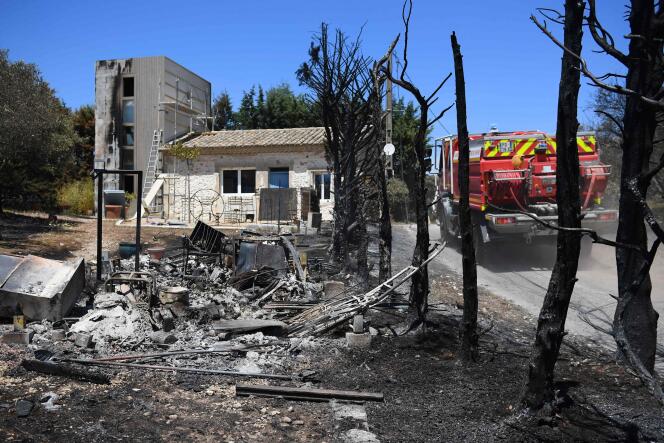 A fire truck drives past damages near a house under construction after the passage of a wildfire near Graveson, south of Avignon in southeastern France, on July 15, 2022.